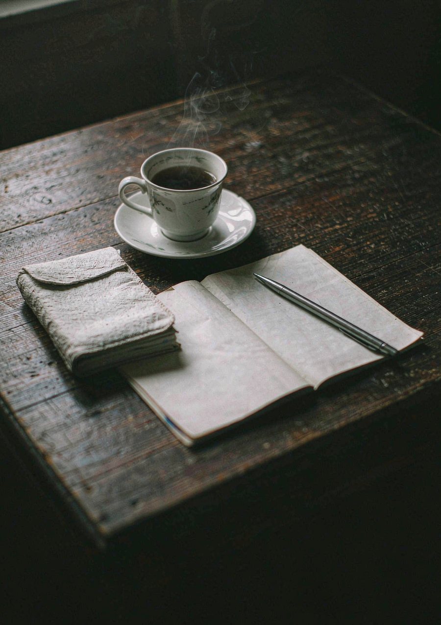 Carte dépliée, carnet et tasse de thé sur une table en bois